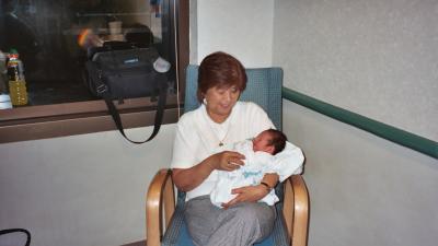 Tricia's mom, Lola, holding Evan in the hospital