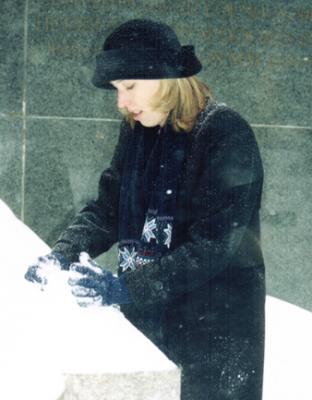 Making a snowball to throw at her unsuspecting mother