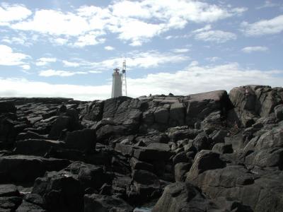 Rocky coast with mountains and lighthouse