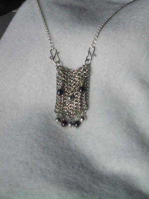This hand-made sterling chain-maille bag is about 3x4cm, and is accented by fresh-water pearls and sterling silver bells.  It weighs about 40 grams. not for sale