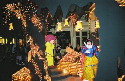 At a nighttime parade in Disneyland.   Snow white and a dwarf, possibly Dopey?