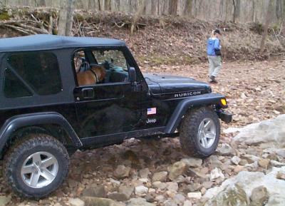 Chris and Biscuit four-wheeling in a creekbed