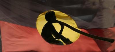 Abstract of young didgeridoo player on aboriginal flag