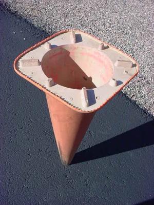 cone standing on head on blacktop pavement