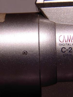 Notice the screw present on either side of the lensbarrel of the c2100 which is not present on the previously displayed E100. No gap appears at anytime when the weight of extra glass is attached.
