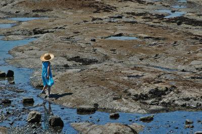 Girl with a sun hat at low tide