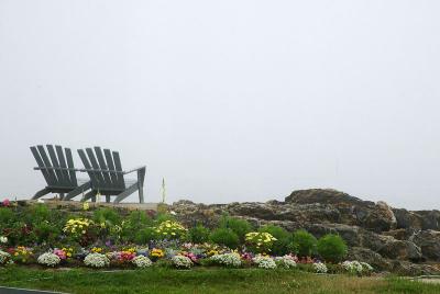 Adirondack chairs face Linekin  Bay from in front of Ocean Point Inn.