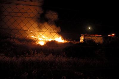 Fire fighters try to stop the fire from spreading toward the town