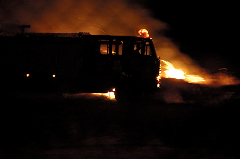 Fire fighters move their truck as the wind changes direction and the fire spreads towards them