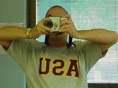 Jeffrey Lewis in hisUSA - ASU t - shirt taking a selfee