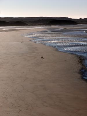 Walkers exercising along Settlers Beach