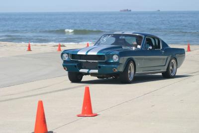 Green 66 Mustang waves with cones