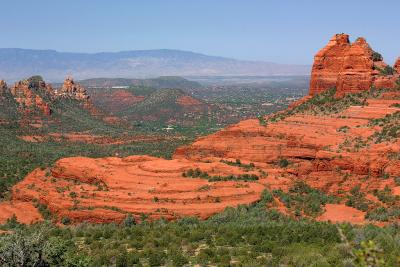 The view along Schnebly Hill Road in Sedona, Arizona. The cow pies, strange rock formations on the ledge to the left of the peak, can be seen against the backdrop of the city of Sedona in the valley.