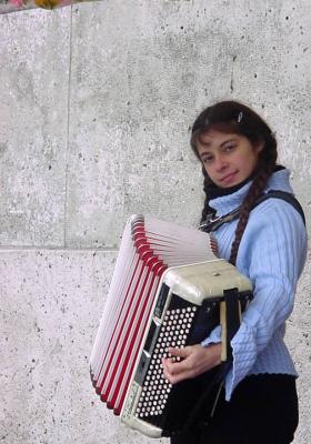 A young accordianist entertains outside the church