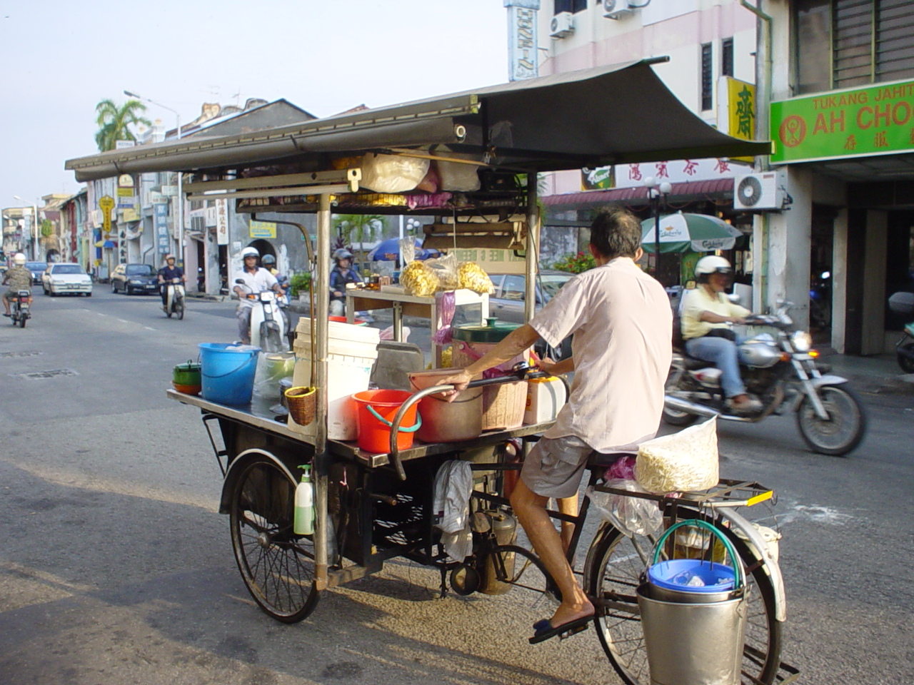 a street vendor pedals his cart to work
