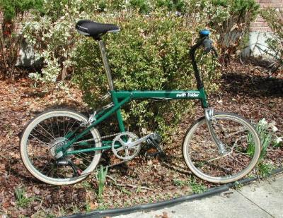 John Chiarella's CUSTOM TWENTY-FOUR PURSUIT SWIFT FOLDER chained to a shrub to prevent it from taking off on its own....