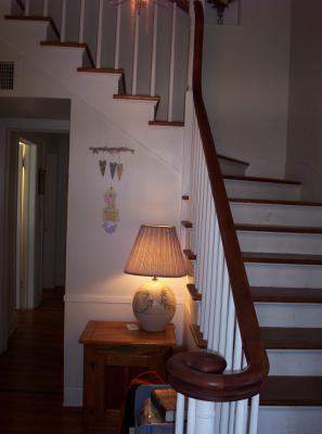 When you first walk in our front door, this is straight ahead of you.  There is a closet that goes underneath the stairs, starting right behind the wall you see behind the lamp.  The closet is L-shaped and goes down as far as the next to lowest stair step.  As you look straight in this photo, there is a short hall that connects this foyer area to a long hallway that runs most of the width of the house's backside, connecting the master bedroom, downstairs bath and kitchen.