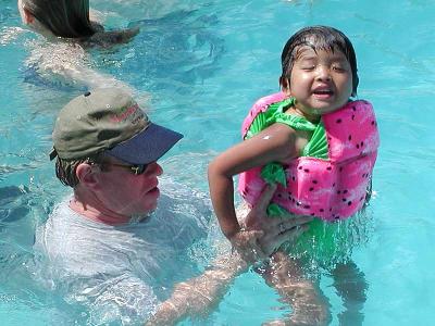 The Watermelon Girl and her dad play in the pool.