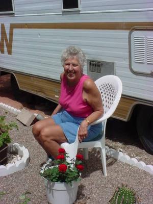 Joan sitting with the beautiful rose bush