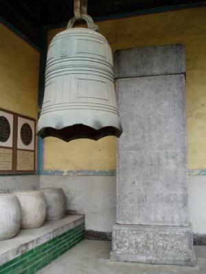 Bronze bell and stone drums. The stele in the picture contains inscription describing these items.