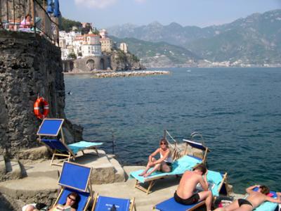 Judy near hotel pool, which is the raised area on the left. Topless woman was lying on her stomach. Atrani is in the background.
