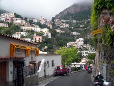 Missed last bus to Amalfi. Entered shop on left. Offered & ate cake with group of guys, before guy there drove us to Amalfi.