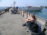 Judy waiting for the boat to the Emerald Grotto - a cavern with stalactites and stalagmites & known for its light effects.