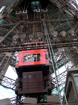 The guts and an elevator of the Eiffel Tower. The Tower looks delicate from afar but  imposing close-up.