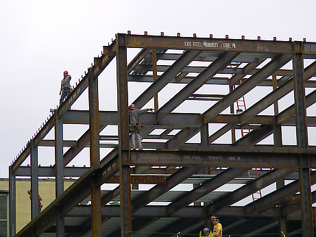 Workers walking on girders during construction of an addition to Kent Hall - Kent State University 6-03