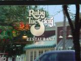 a sign in a reflection <br>Ruby Tuesday restaurant