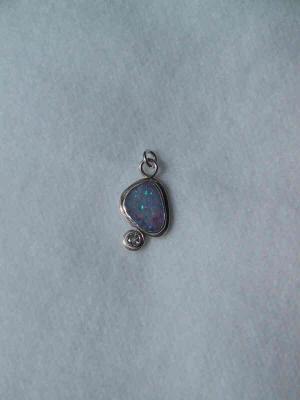 A bezel-set opal & faceted colorless topaz.   Approx 2cm long. SOLD