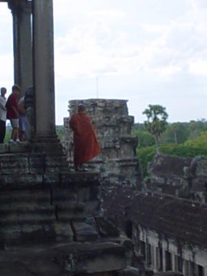 monk watching Angkor Wat