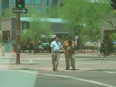 two men waiting to cross the street