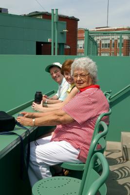 Dad, Charlotte and Mom sitting in the Monster Seats at Fenway Park.