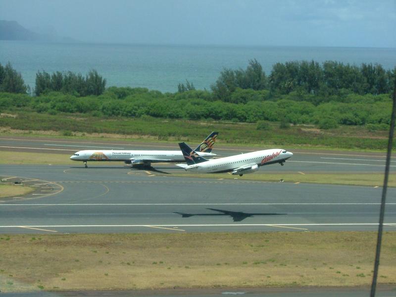 AQ221 Takes off with TZ taxiing to the terminal building