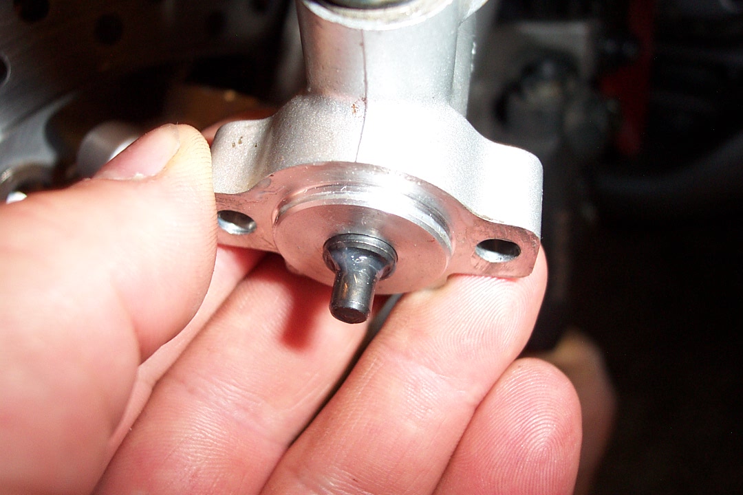 By pushing up on the left brake caliper, you should see the actuator come out as shown here if it is working properly
