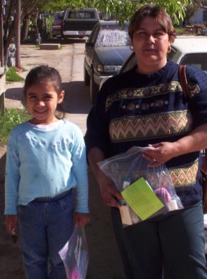 A recipient of a kit.  Each kit had (new, sample size) soap, shampoo, toothbrush/paste, a washcloth, a new (Giddeon) New Testament Bible printed in Spanish and a bright-colored card that had the testimony of one of our group members, also translated in Spanish.  (This photo shows a bright green card).