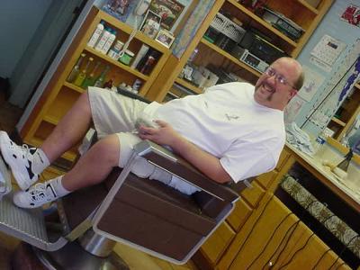 bill leaning back in his barber Bill chair