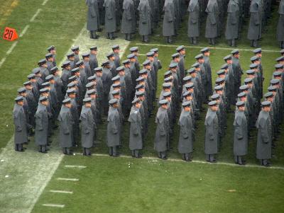 The cadets stand stoically even after being pelted with snowballs by some rowdy midshipmen