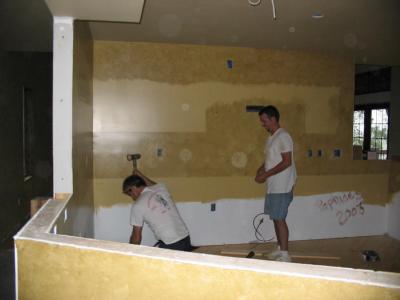 The men finish up laying the pine flooring in the kitchen