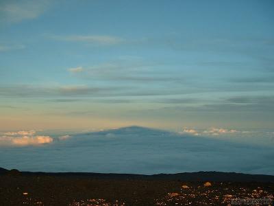 Mauna Kea casts a shadow into the sky at sunset.