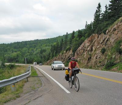 A determined cyclist struggles up a stretch of the Cabot Trail to a scenic lookout.