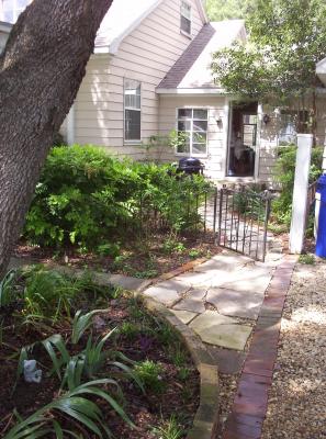A photo showing our breezeway garden path that I made using flat concrete & stones along with bricks all found on our property. It was well worth the labor to create it as I love the effect it added to our country home.