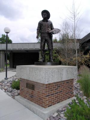 A bronze statue of Charlie Russell with palette and brush stands guard out front.
