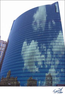 Sky and Clouds Reflect off of a Building Along the Chicago River