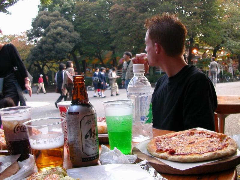 Pause pizza dans le parc, en observant la foule des passants