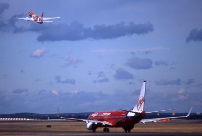 Qantas B737-800 departing + Virgin Blue taxing.jpg