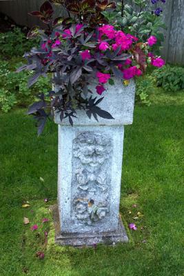 Stone Pedestal with Flowers in Side Garden
