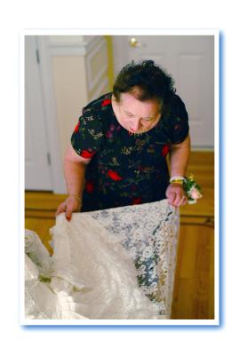 Marcelle revisits the wedding dress and inspects the lace.