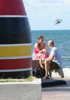 Man asking woman to marry him, at the Southernmost Point in the U.S.